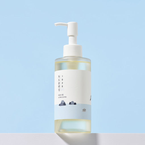 Imagem do Round Lab 1025 Dokdo Cleansing Oil, formulado para remover suavemente maquiagem e impurezas enquanto mantém a hidratação natural da pele, sem sensação oleosa. Ideal para todos os tipos de pele, deixando-a limpa, fresca e equilibrada após cada uso.